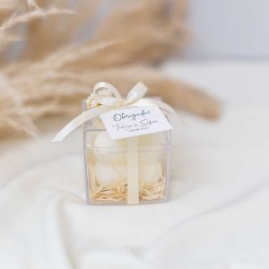 vela de bolinhas em caixa transparente e com etiqueta personalizada. decorada com flores secas para lembrança de casamento